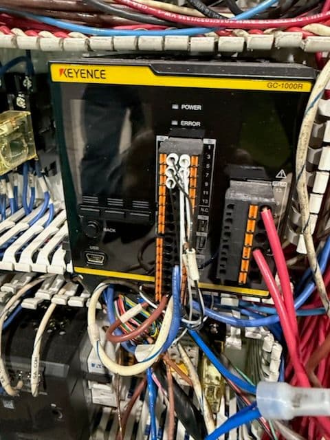KEYENCE GC-1000R control unit with tangled wiring in electrical panel setup.